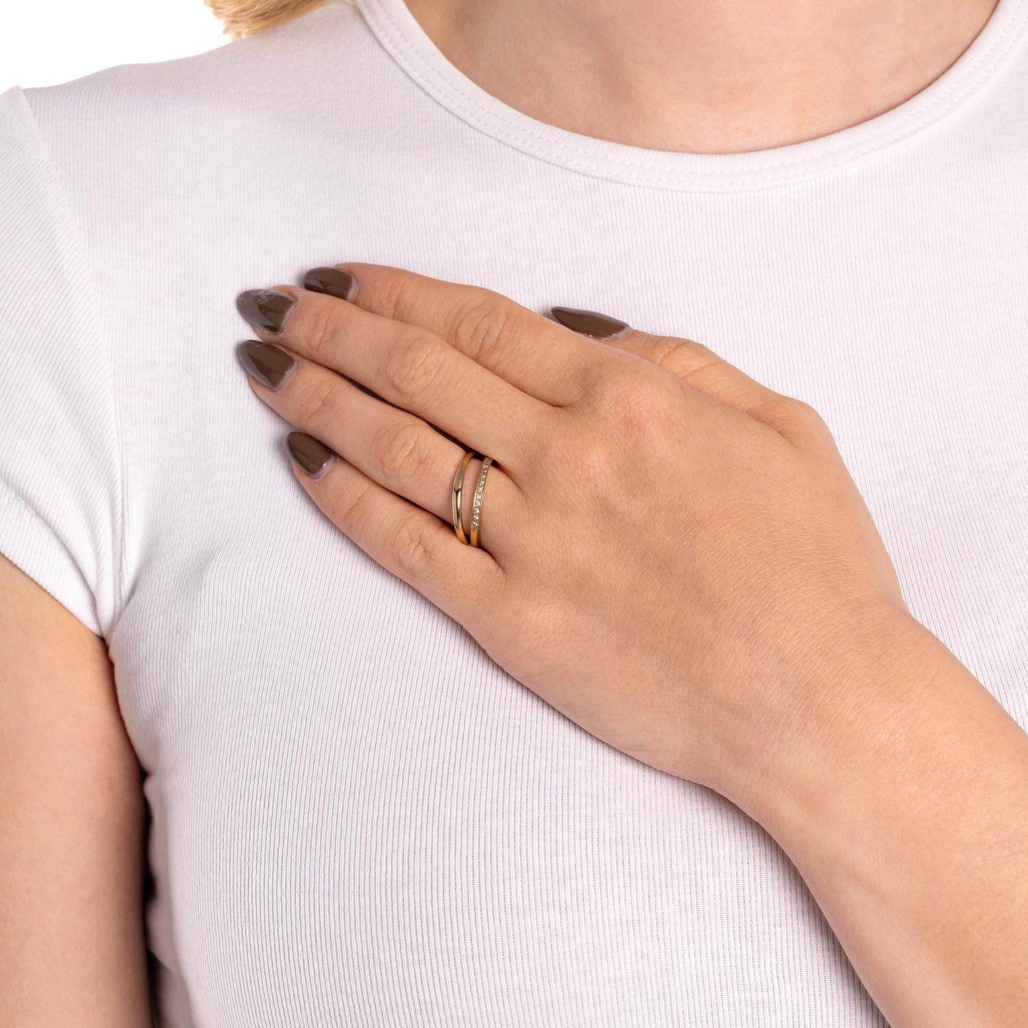Frau mit goldenem Ring TINI 17 an der Hand, weiß gekleidet
