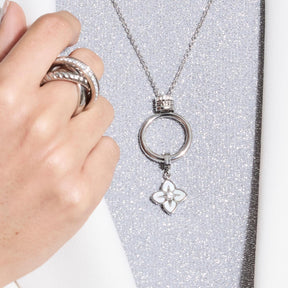 Hand mit Ring und Anhänger REIJA Clip & Mix mit Kleeblatt-Charm an Kette