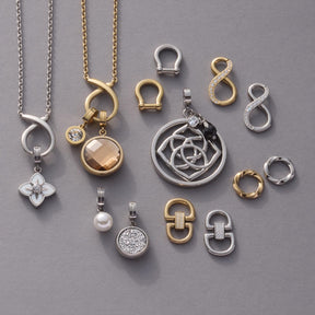 Schäkel TUXIDO Clip & Mix in Silber und Gold mit Kettenanhängern auf grauem Untergrund