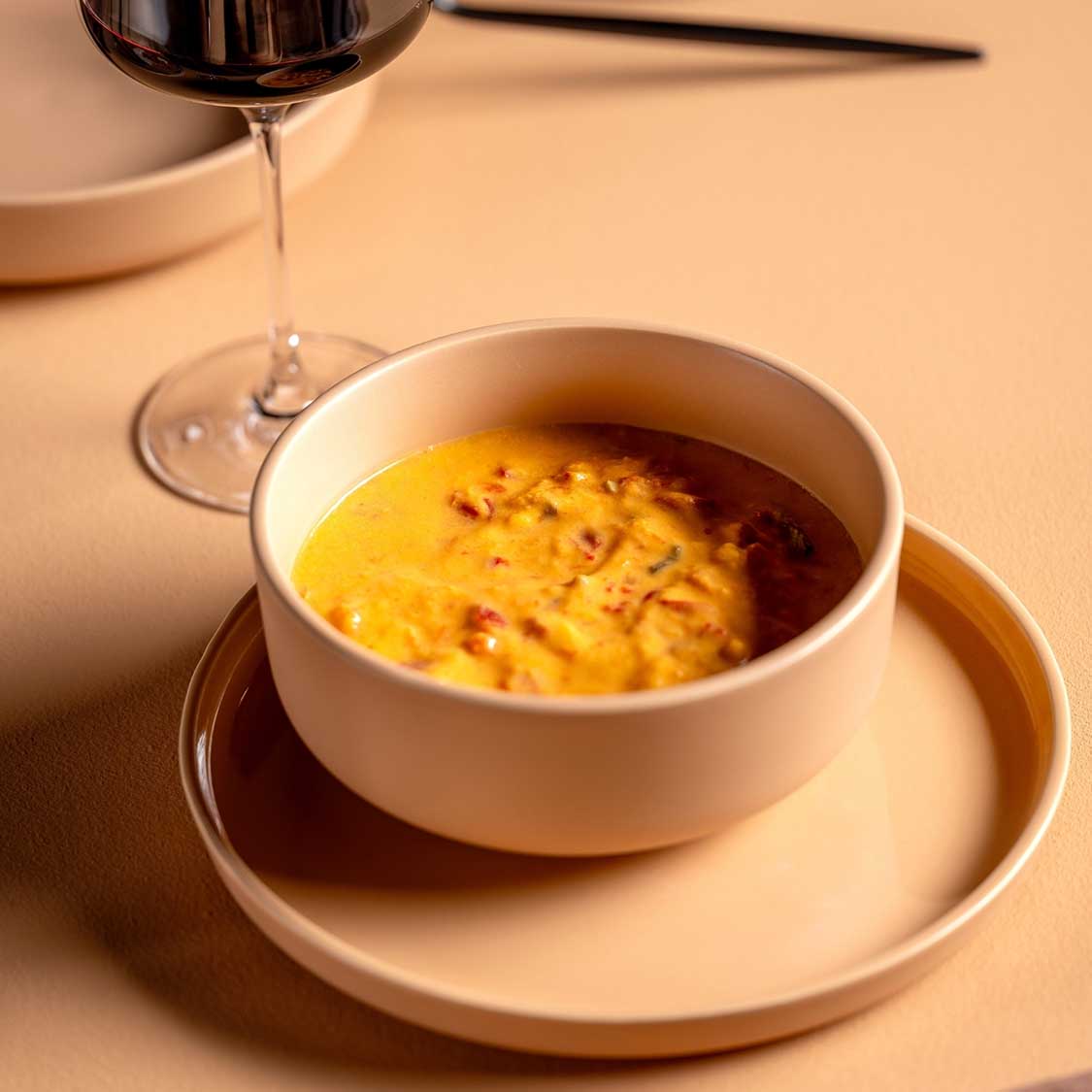 Keramikteller ROMA in apricot, gedeckter Tisch mit Suppe und Weinglas