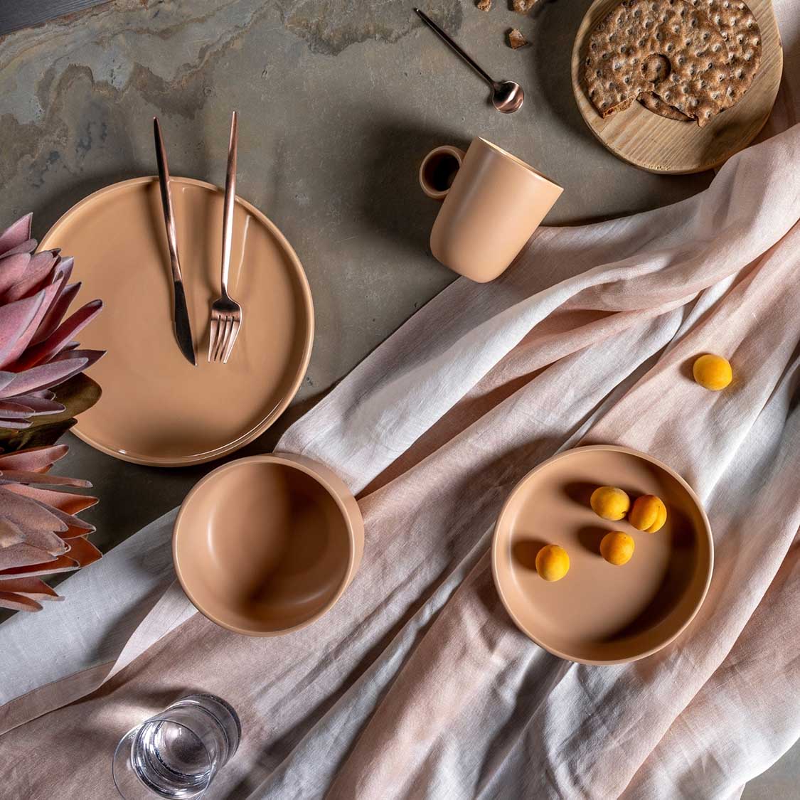 Keramikteller ROMA apricot auf gedecktem Tisch mit Besteck, Blume und Deko