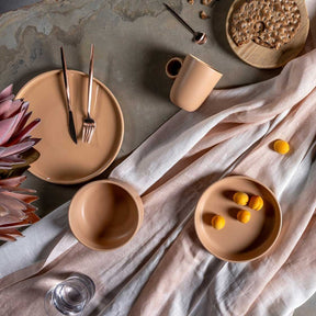 Keramikteller ROMA apricot auf gedecktem Tisch mit Besteck, Blume und Deko