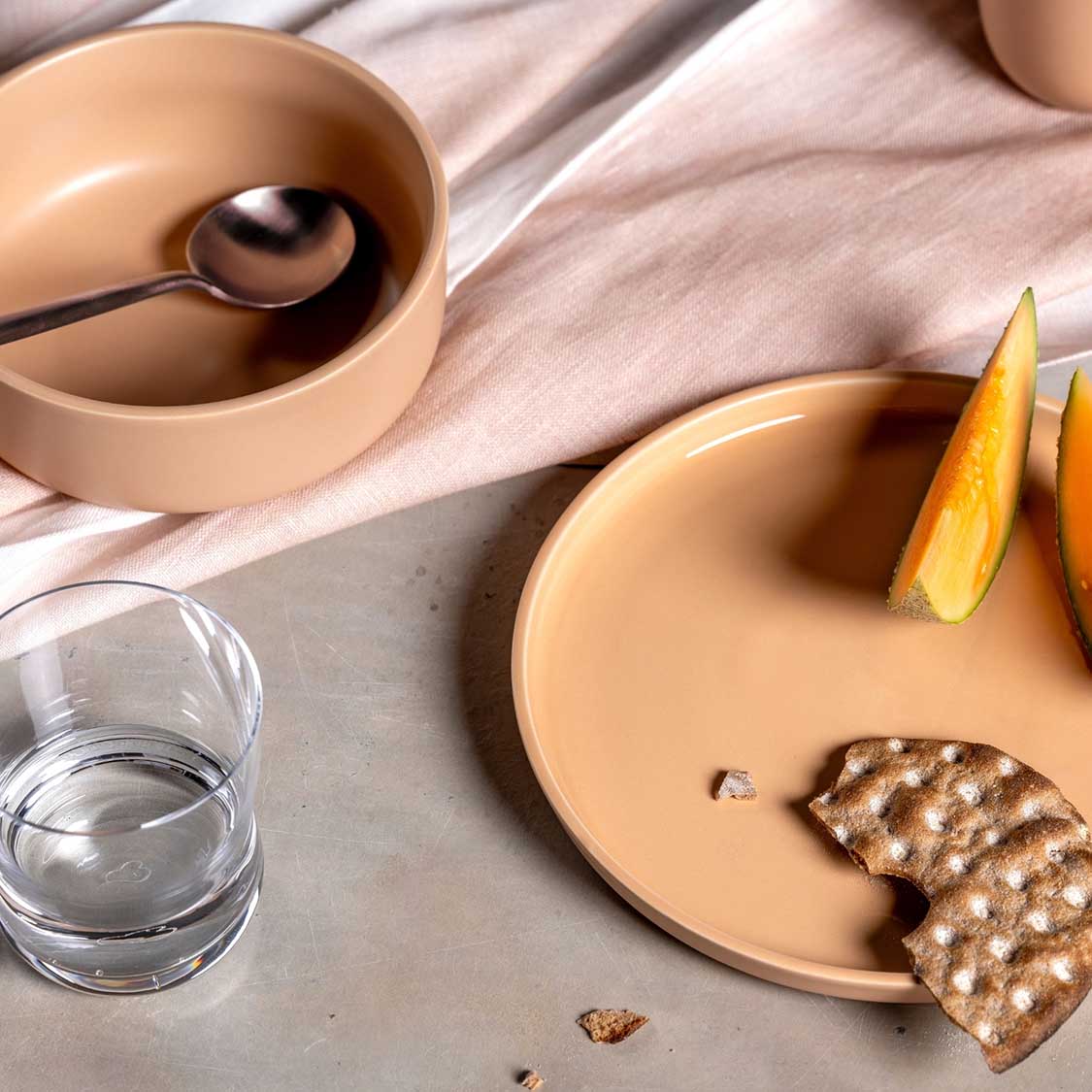 Keramikschale ROMA apricot mit Cracker, Orangenscheiben und Wasser auf Tuch