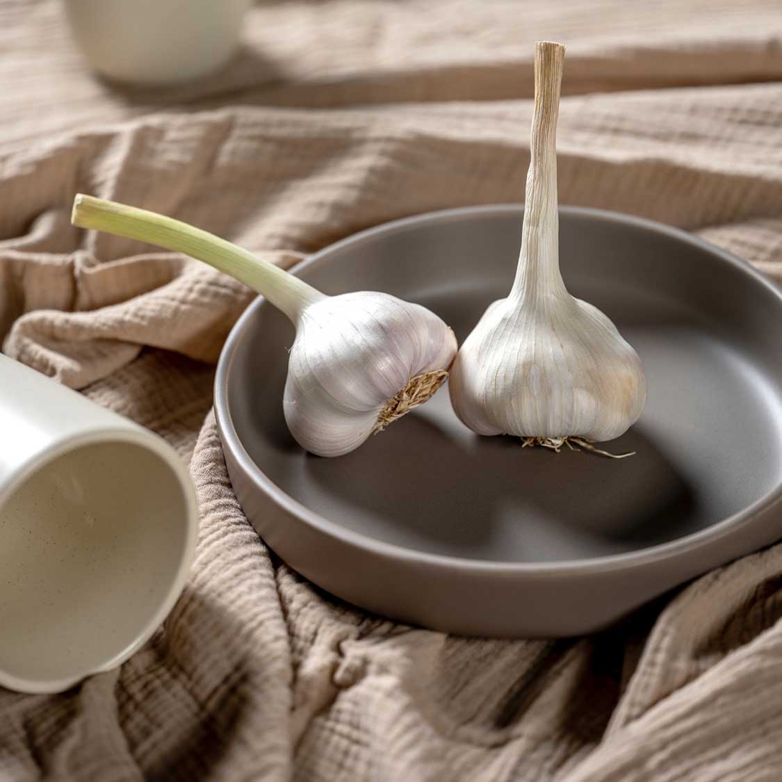 Keramikteller ROMA auf Leinentuch mit Knoblauch und Keramikschale