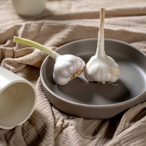 Keramikteller ROMA auf Leinentuch mit Knoblauch und Keramikschale