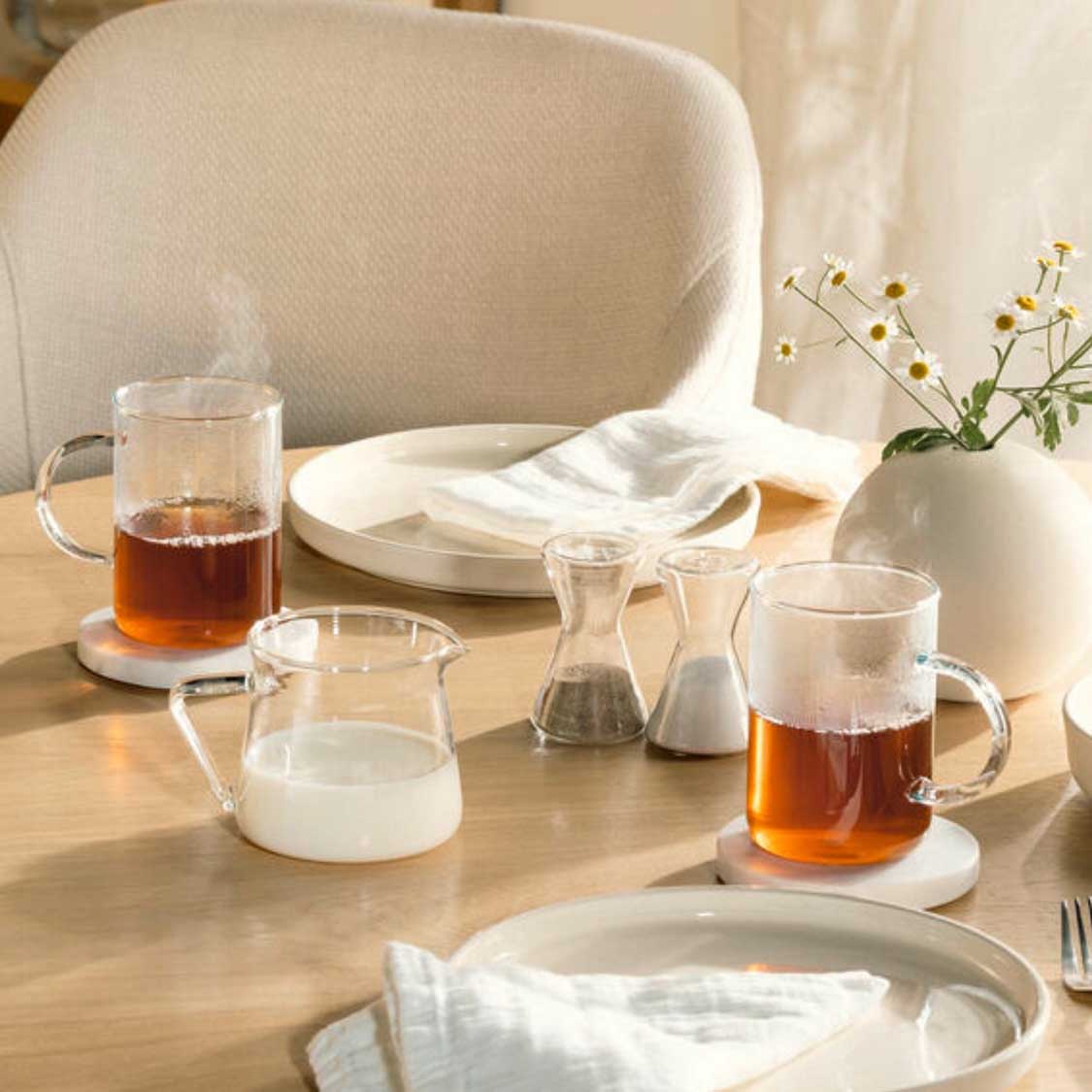 Teegläser NOVO auf gedecktem Tisch mit Teekannen und Blumenvase