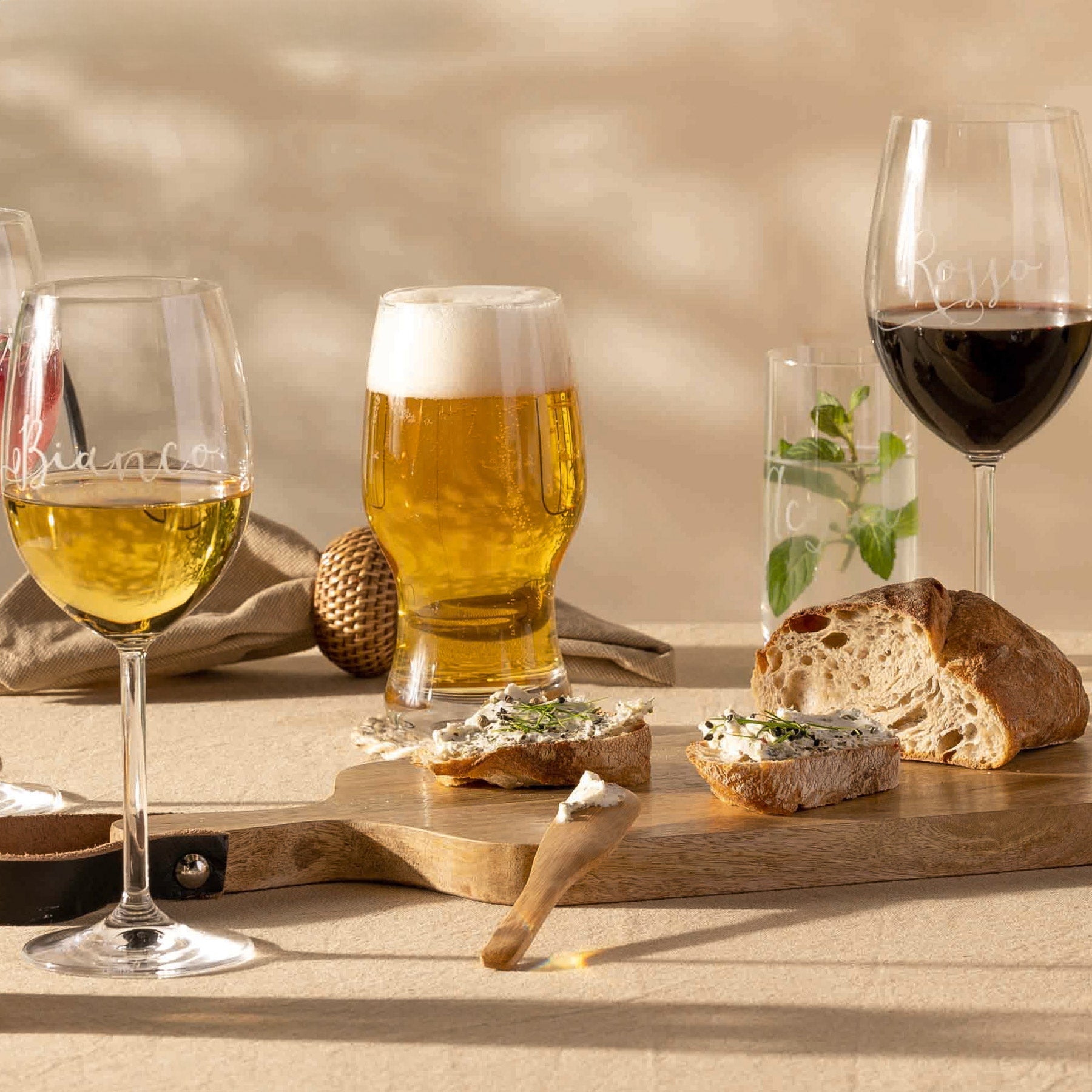 Bierglas TAVERNA mit Bier gefüllt auf gedecktem Tisch mit Wein und Brot