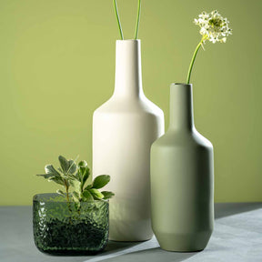 Vase MARTELLO 13 cm grün mit Dekoration auf grauem Untergrund vor grünem Hintergrund