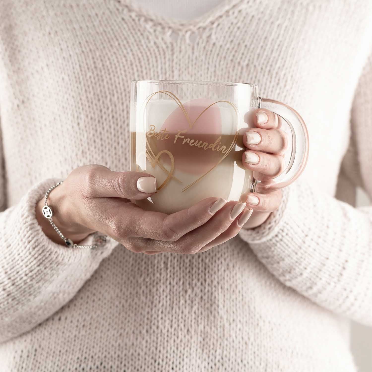 Frau in Creme-Pullover hält rosé Glastasse mit "Beste Freundin" Gravur