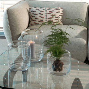 Windlicht LAGO auf Glastisch in Wohnzimmer mit Kerze und Pflanze