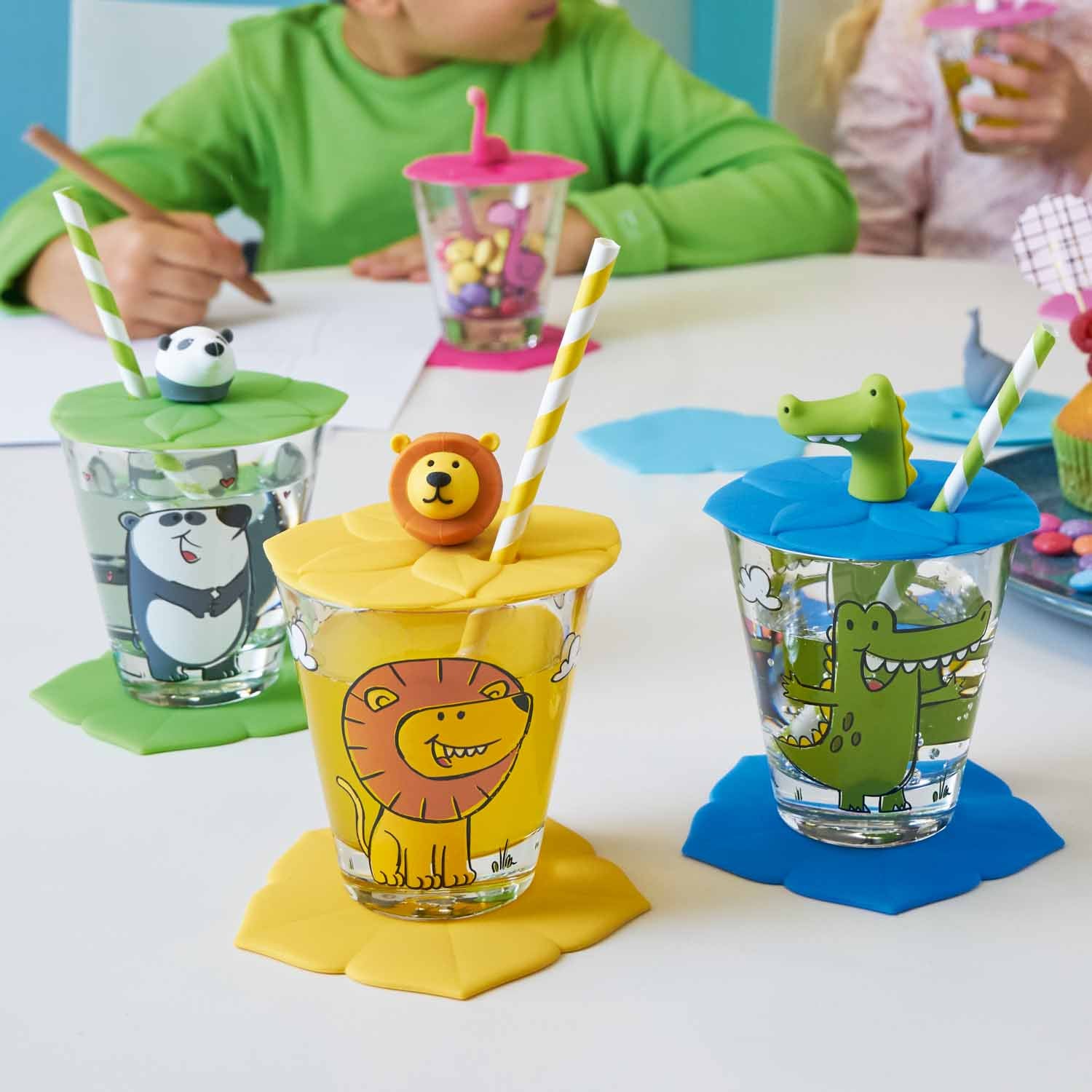 Kindertrinkset BAMBINI 3-teilig Krokodil mit bunten Glasbechern und farbigen Deckeln am Tisch
