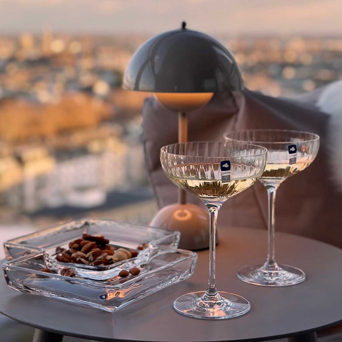 Kabarett SEZIONE mit Weingläsern und Nüssen auf Dachterrasse mit Stadtblick