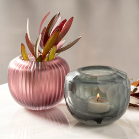 Vase BELLAGIO anthrazit neben rosa Vase mit roten Blüten und brennender Kerze