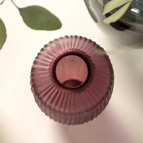 Vase BELLAGIO in Beerenfarbe von oben, gerillte Oberflaeche, mit Pflanzenblaettern daneben