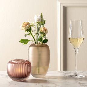 Vase BELLAGIO mit Blumen auf Marmortisch, daneben Weinglas und rote Kerze