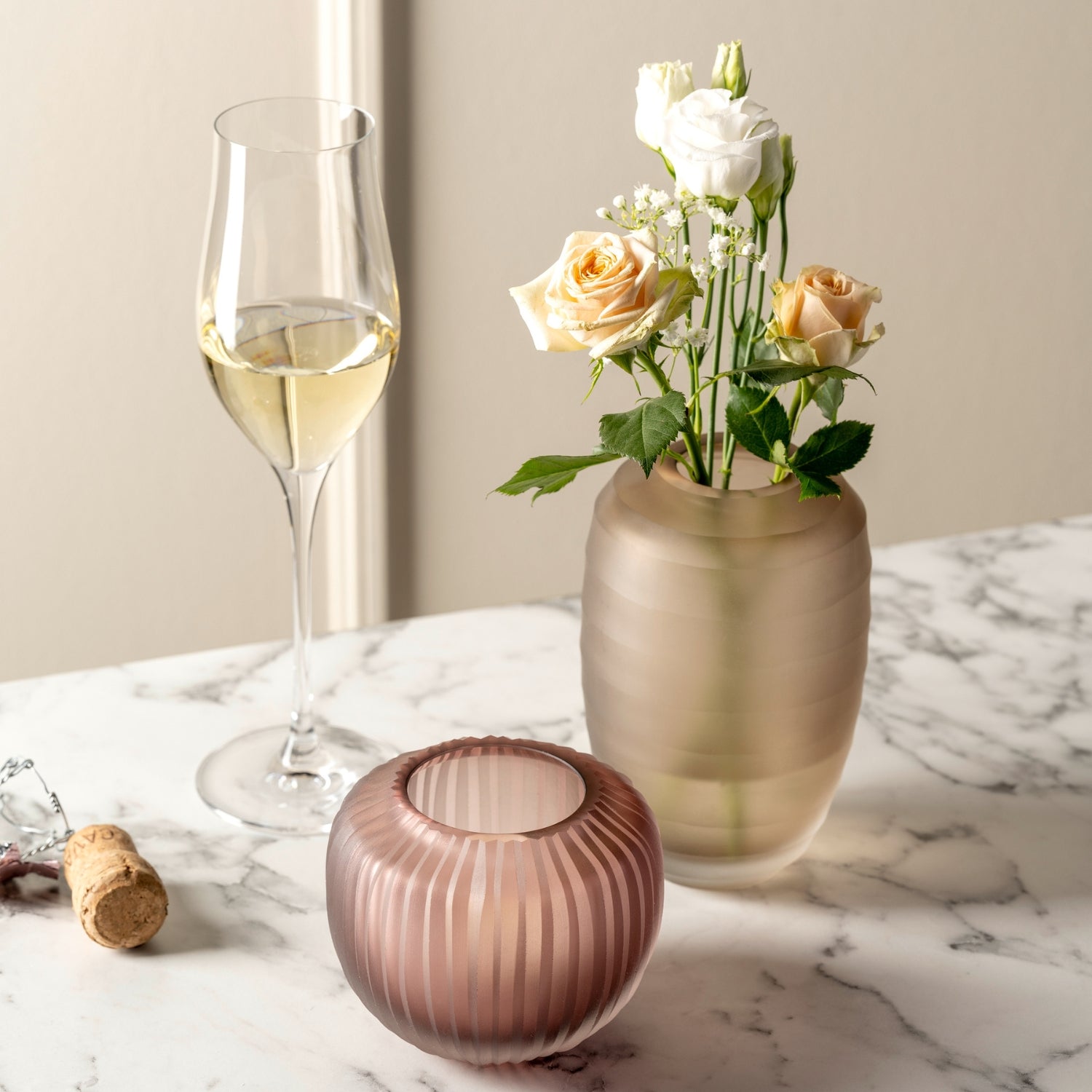 Vase BELLAGIO beige mit Blumen auf Marmortisch, Sektglas und Korkenzieher