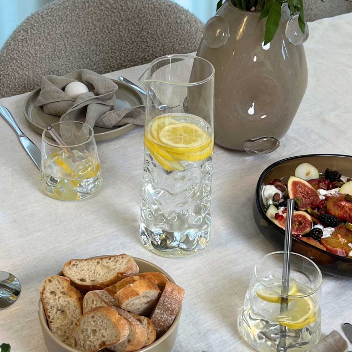Trinkgläser SANO mit Zitronenwasser auf gedecktem Tisch