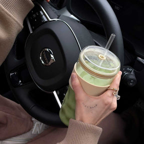 ToGo Becher SANO in Autohalterung, Frau mit Getränk im Auto