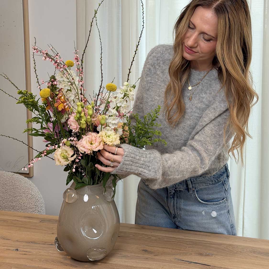 Vase HAZEL 25 cm beige mit Frühjahrsblumen gefüllt, von Frau gehalten