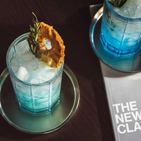 Longdrinkgläser SPIRITII NOVA mit blauem Cocktail, Eis und Ananasgarnitur auf dunklem Untergrund