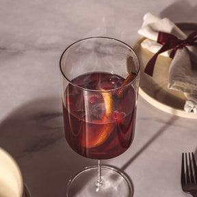 Kelchglas BASSO mit rotem Getränk und Eiswürfeln, gedeckter Tisch