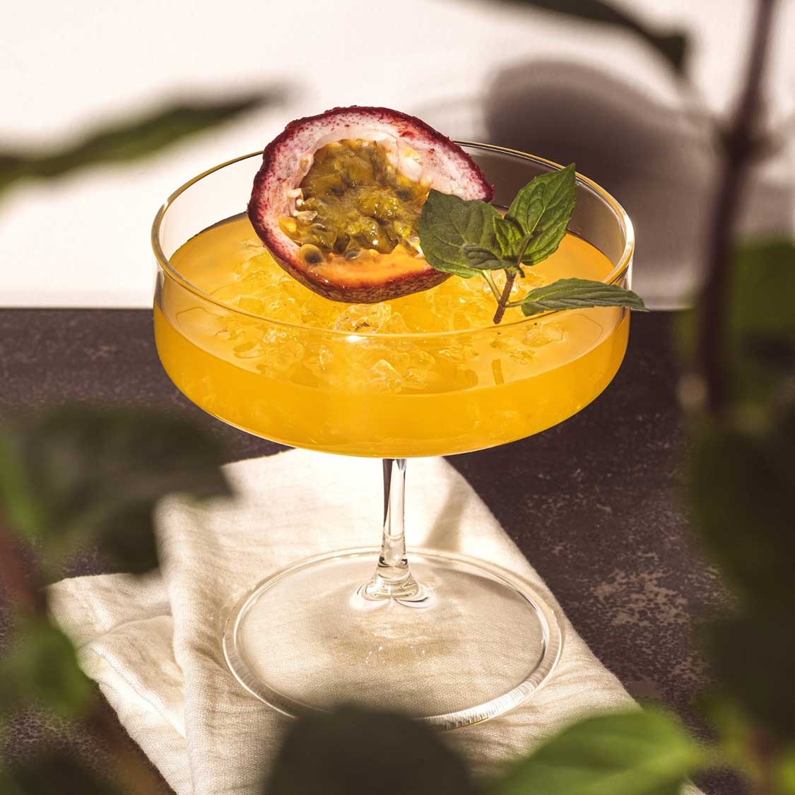 Schale auf Fuß BASSO mit gelbem Cocktail, Passionsfrucht und Minze, Sonnenlicht