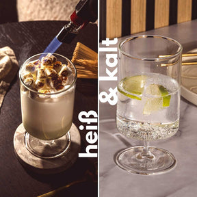 Zwei Trinkgläser auf Fuß mit Getränken und Eiswürfeln, Limettenscheiben, Cocktail-Setting