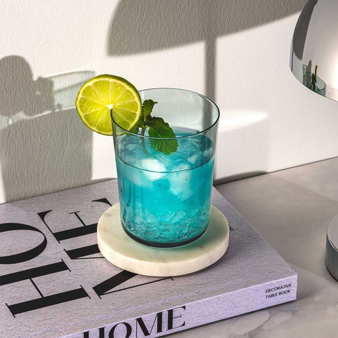Trinkglas LEGGERO 330 ml mare mit türkisem Wasser, Zitronenscheibe und Minze auf Untersetzer