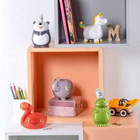 Spardose BAMBINI Einhorn in Regalumgebung mit Deko und Büchern