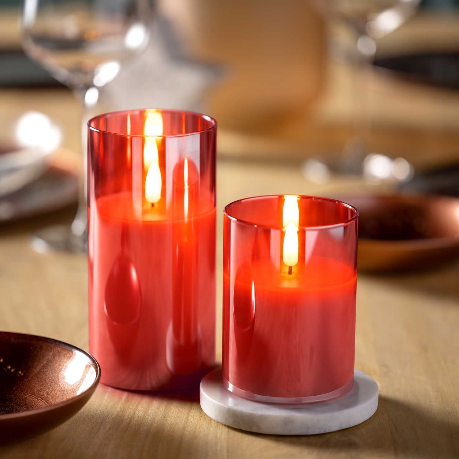 LED Kerze rot auf gedecktem Tisch mit Gläsern und Tellern