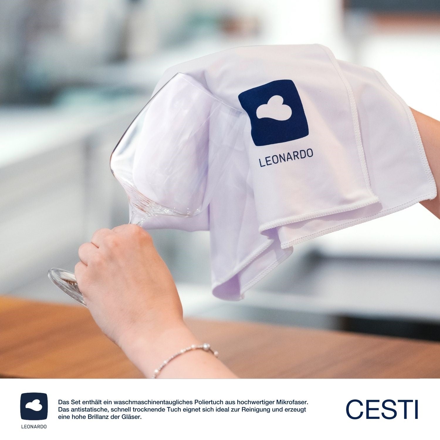 Hand hält Poliertuch mit Leonardo-Logo, Produktverpackung im Hintergrund