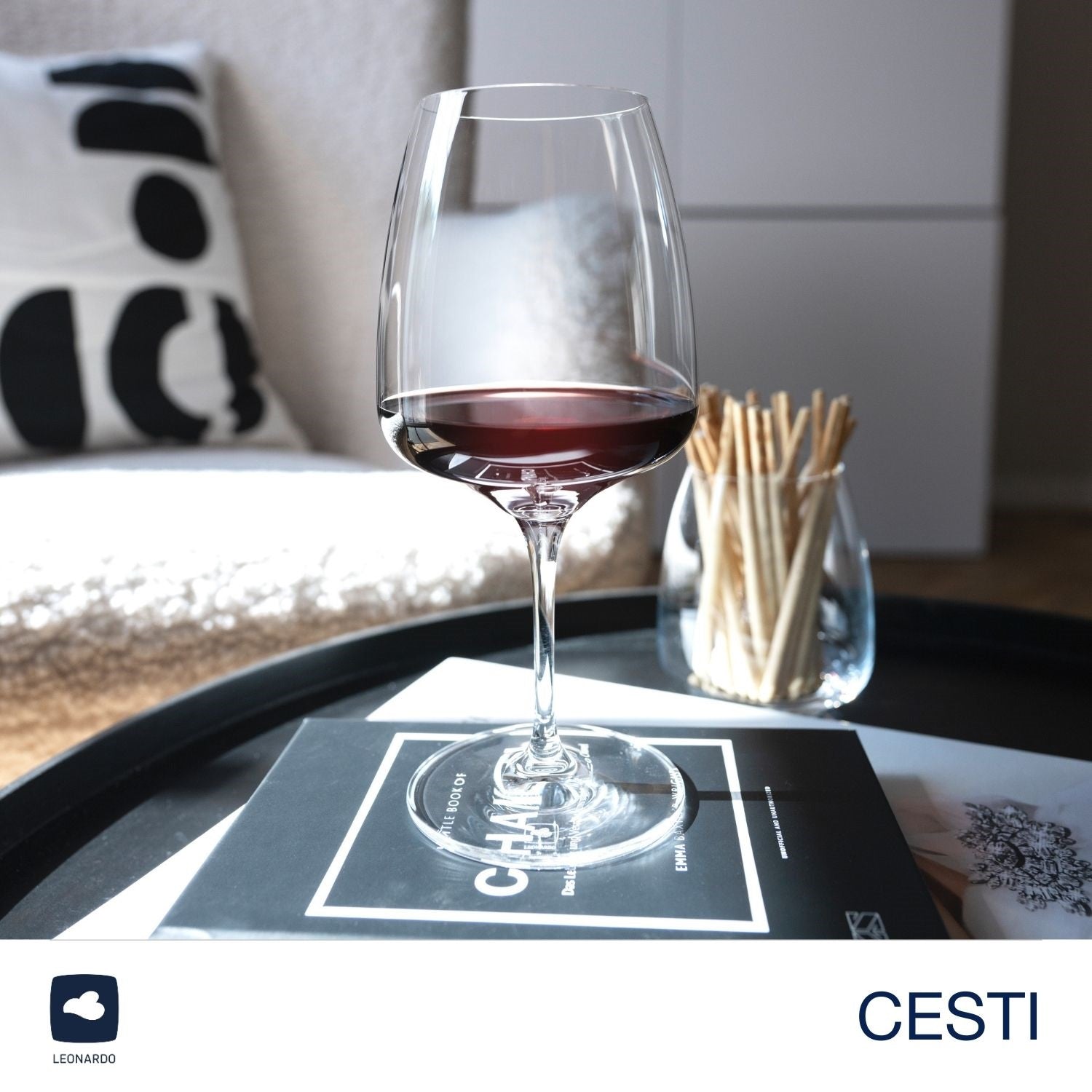 Rotweinglas CESTI mit Rotwein auf Tablett in Wohnraum
