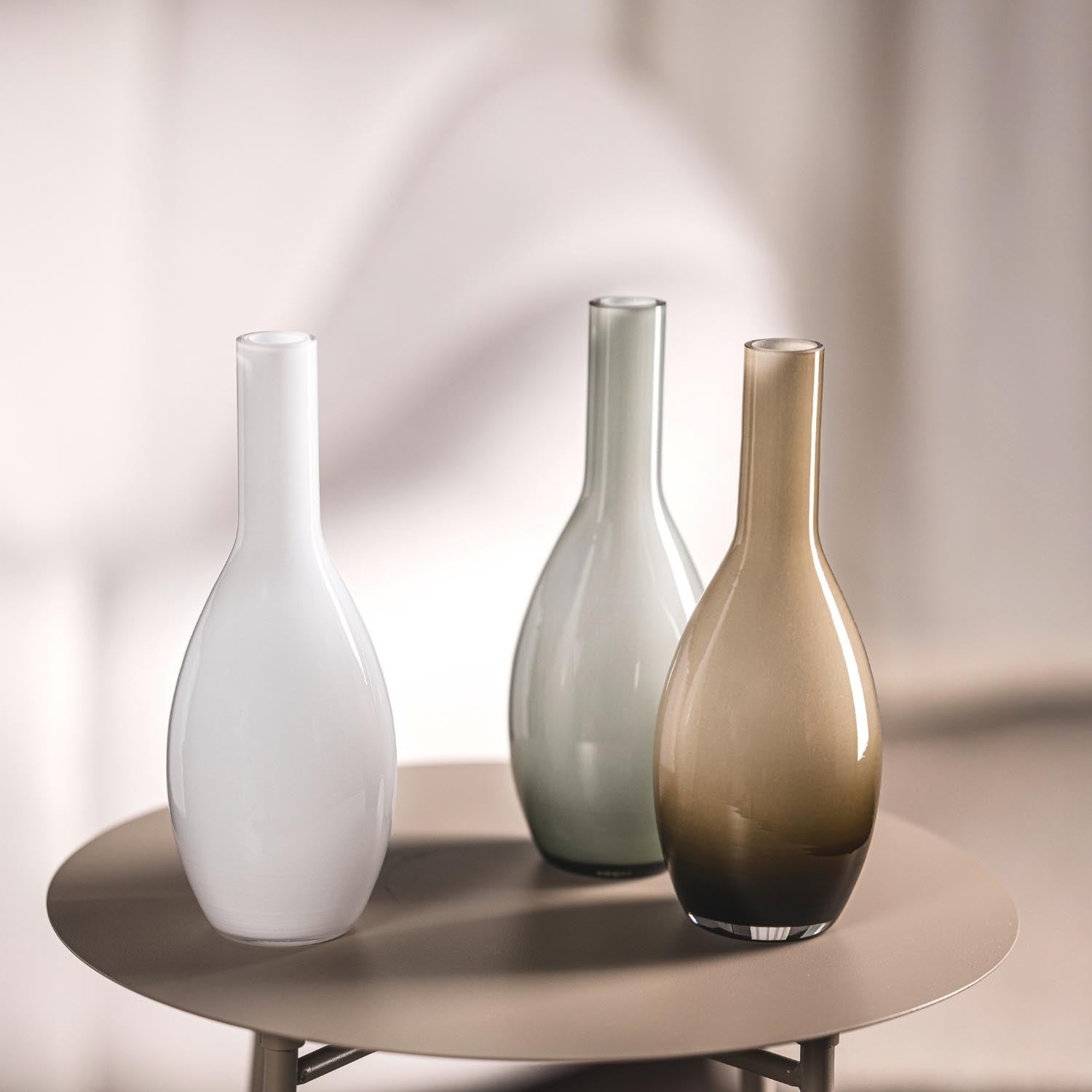 Drei Vasen in verschiedenen Farben auf rundem Tisch, braune Vase BEAUTY im Vordergrund