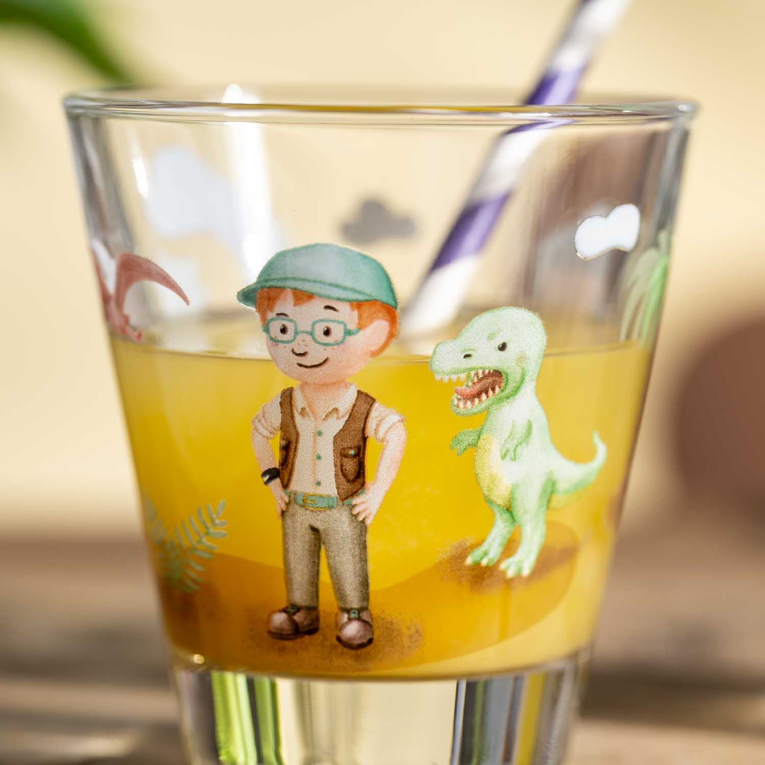 Trinkglas mit Junge in Khaki-Outfit und grünem Dinosaurier auf gelbem Grund