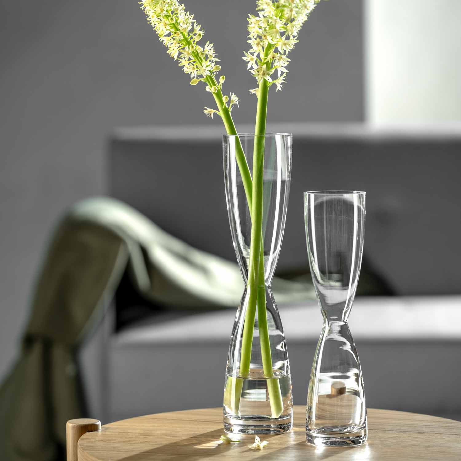 Solifleurvase DIABOLO mit grünen Blütenstielen auf Holztisch in Wohnraum