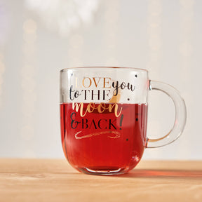 Tasse EMOZIONE mit rotem Inhalt und "Love you to the moon and back" Schriftzug auf Holztisch