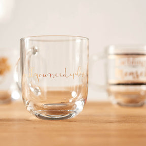 Tasse EMOZIONE mit goldfarbener Gravur "all you need is love" auf Holztisch