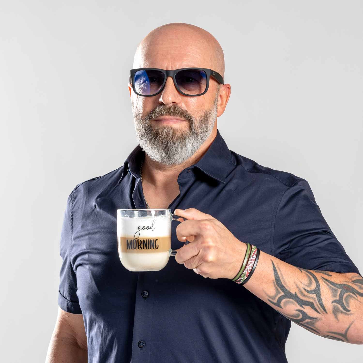 Mann mit Sonnenbrille hält Glastasse UFFICIO mit Gravur "good MORNING