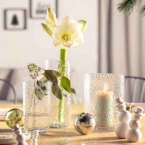 Vase MARTELLO mit Narzisse auf gedecktem Tisch, umgeben von Dekoration