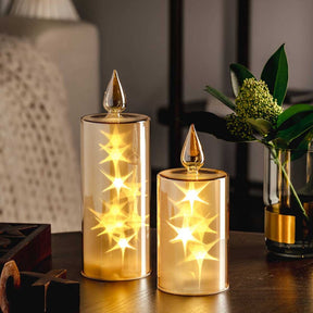LED Kerze CAPANNA gold mit Sternen auf Tisch neben Blumenvase