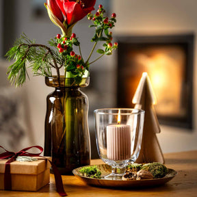 Windlicht CAPANNA auf Tisch in Wohnraum mit Blumenvase und Geschenk