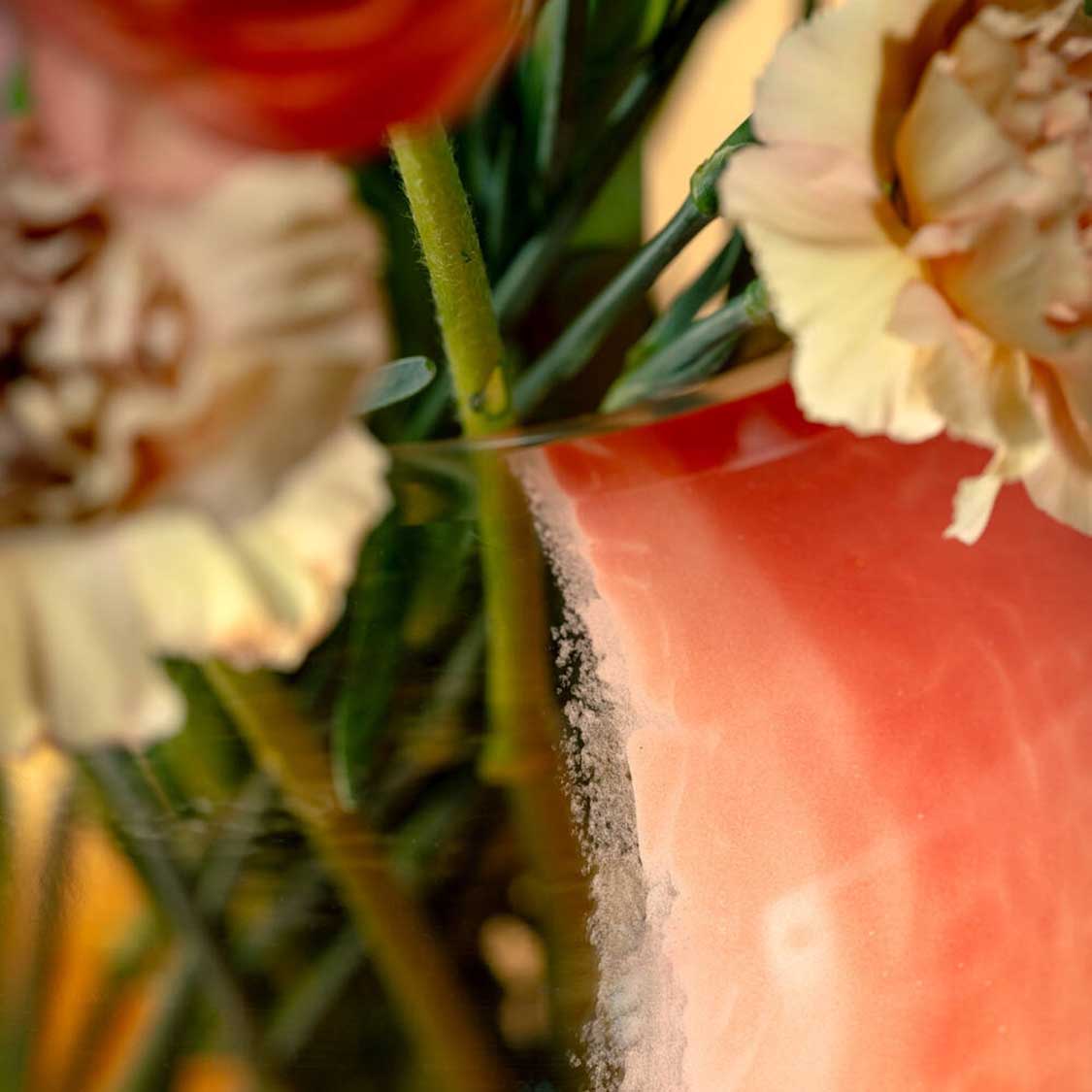 Vase CIPRIA DUE mit Schnittblumen in Nahaufnahme, apricot-farbenes Glas mit grünen Stielen