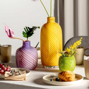 Vase FILO COLORI grün auf gedecktem Tisch mit Blumen und Gebäck