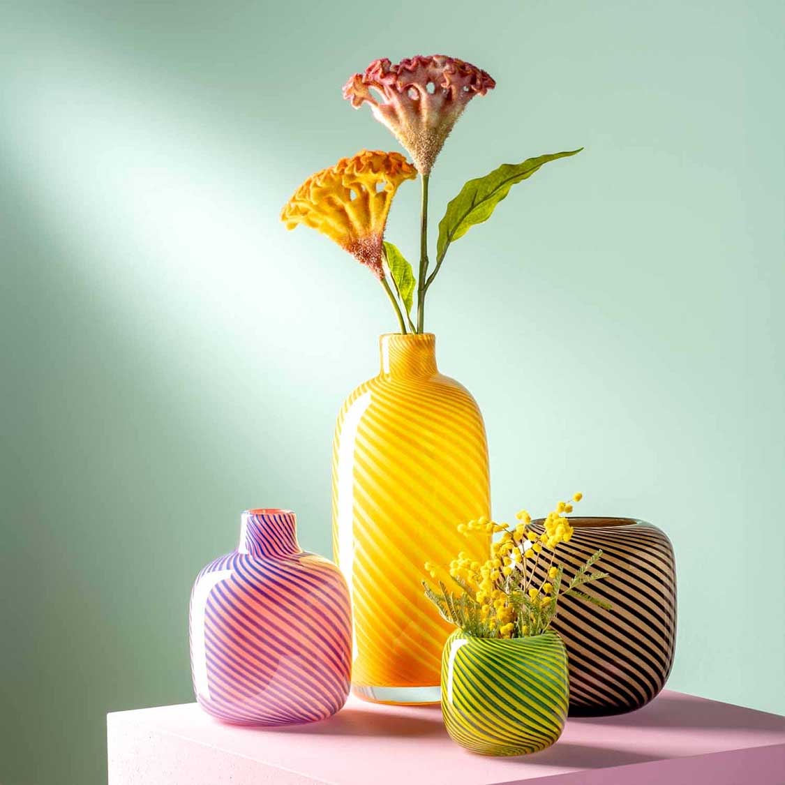 Vase FILO COLORI braun mit anderen Vasen und Blumen auf Podest