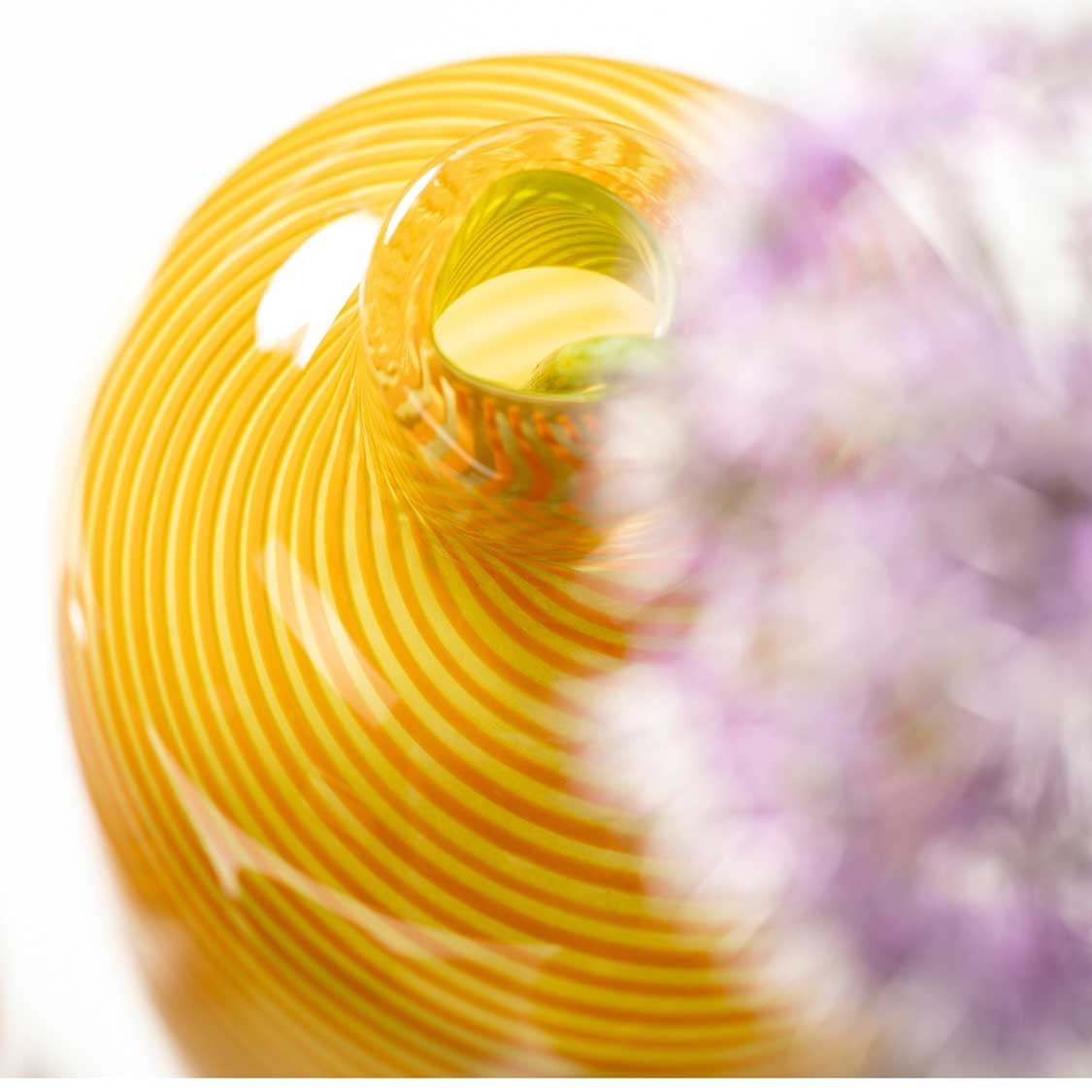 Gelbe Glaszase FILO COLORI mit Rillenstruktur, verschwommener violetter Hintergrund
