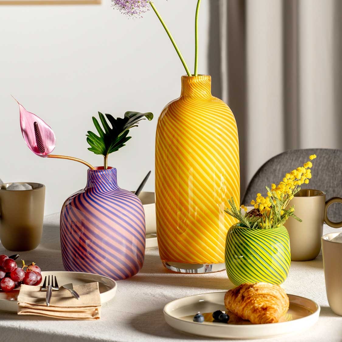 Vase FILO COLORI 32 cm gelb auf gedecktem Tisch mit Blumen und Accessoires