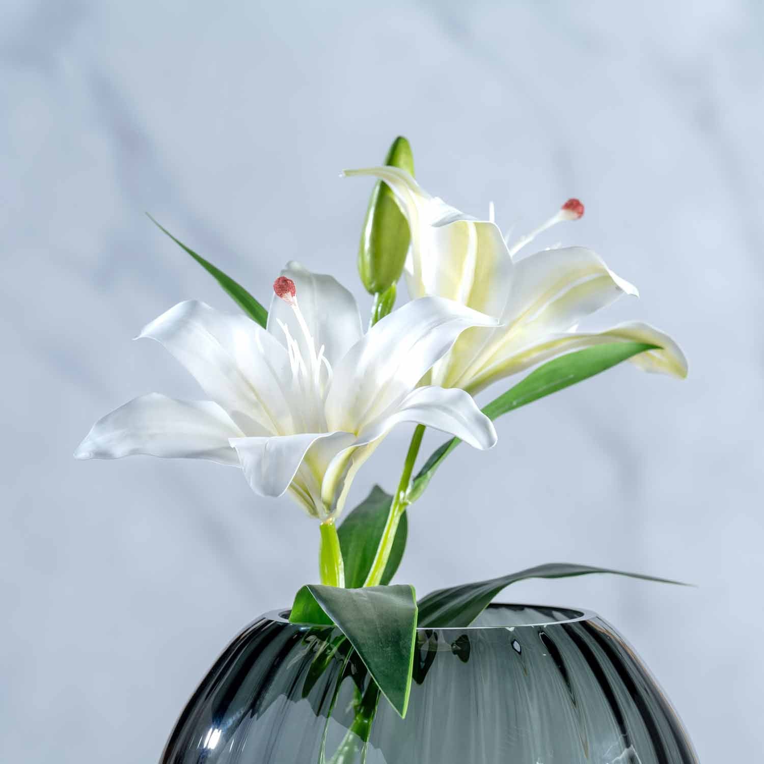Weiße Kunstlilie FIORE in schwarzer Vase vor hellem Hintergrund