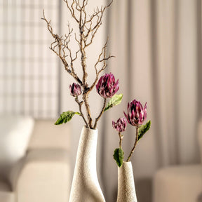 Zweig FIORE in weißer Vase mit dunkelroten Blüten, helles Wohnzimmer