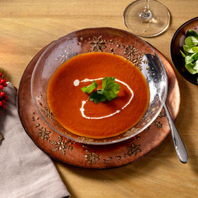 Teller AUTENTICO mit Tomatensuppe, Creme-Garnitur und Petersilie auf gedecktem Tisch