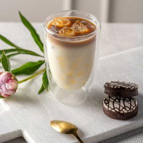 Doppelwandbecher DUO mit Eiskaffee auf Tablett, Blume und Schokolade